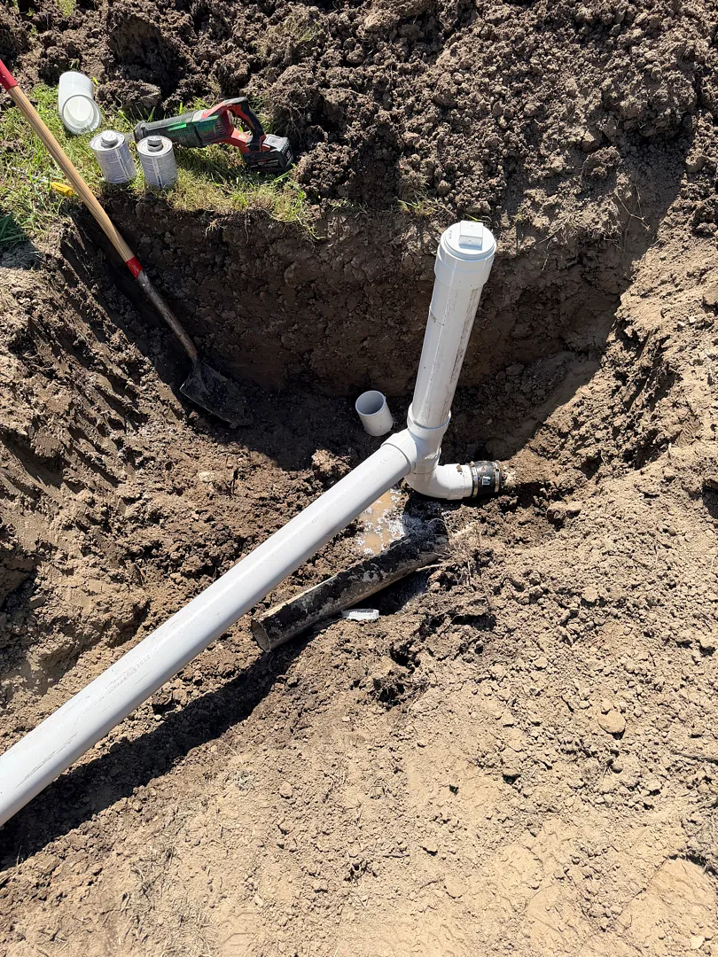 New PVC sewer line and cleanout riser set in an open trench